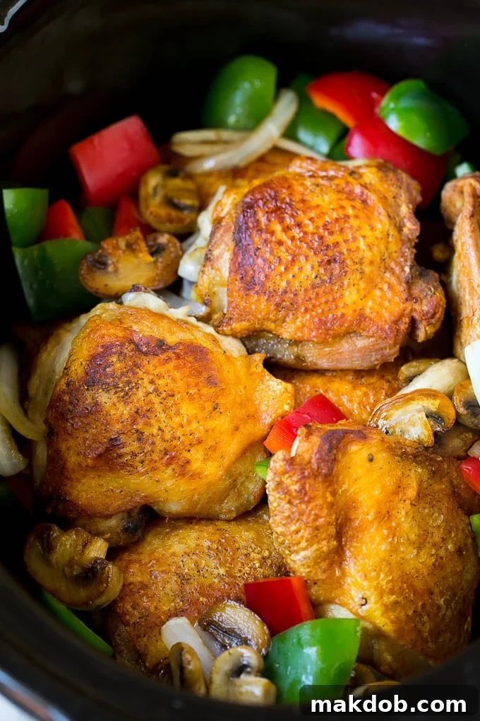 Slow Cooker Chicken Cacciatore Recipe | Italian Chicken #chicken #crockpot #slowcooker #dinner #italianfood #peppers #dinneratthezoo Chicken thighs with peppers, onions and mushrooms inside a slow cooker.