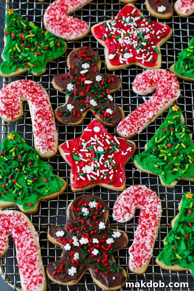 Christmas Sugar Cookies Recipe | Christmas Cookies #cookies #frosting #sprinkles #sugarcookies #christmas #dessert #dinneratthezoo Decorated Christmas cookies cooling on a wire rack, showcasing various designs and colors.