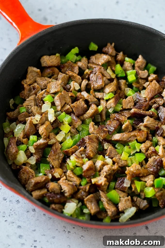 Philly Cheesesteak Dip Recipe | Cheesy Dip | Baked Cheese Dip #steak #dip #appetizer #cheese #dinneratthezoo Seared rib eye steak, peppers and onions in a pan.