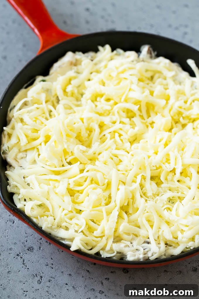 Philly Cheesesteak Dip Recipe | Cheesy Dip | Baked Cheese Dip #steak #dip #appetizer #cheese #dinneratthezoo Philly cheesesteak dip with shredded cheese on top, waiting to go into the oven.