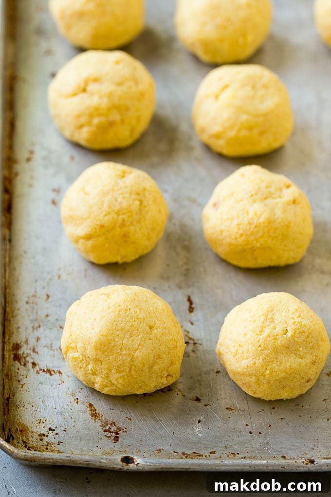 Cake balls neatly arranged on a sheet pan, chilling and ready for dipping.