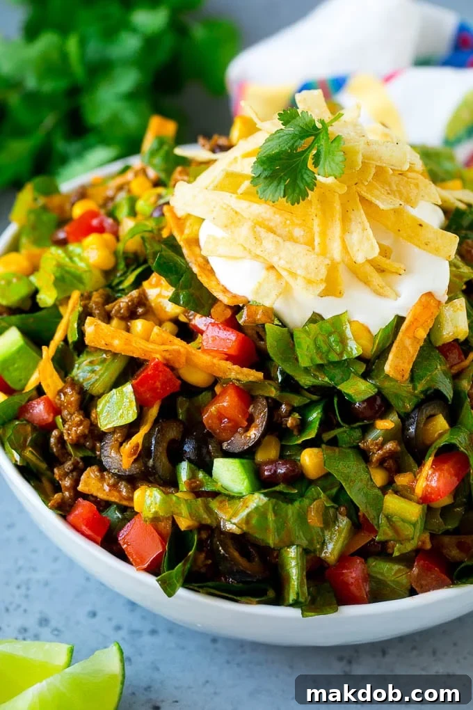 Taco Salad Recipe | Beef Taco Salad | Mexican Salad #salad #taco #beef #lunch #avocado #dinner #dinneratthezoo A bowl of taco salad with ground beef, lettuce, tomatoes, cheese and olives.