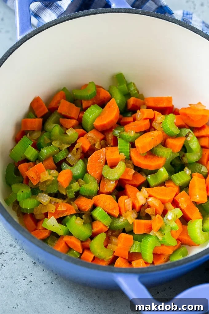 Chicken Vegetable Soup Recipe | Chicken Soup | Healthy Soup | Vegetable Soup #chicken #soup #vegetables #healthy #cleaneating #dinner #dinneratthezoo Carrots, onion and celery in a soup pot, forming the base of the chicken vegetable soup.