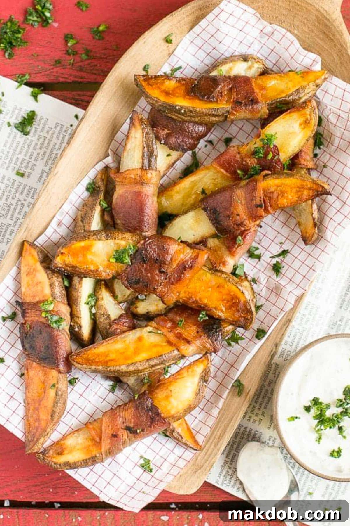 Potato wedges on a sheet of parchment paper that have been roasted.