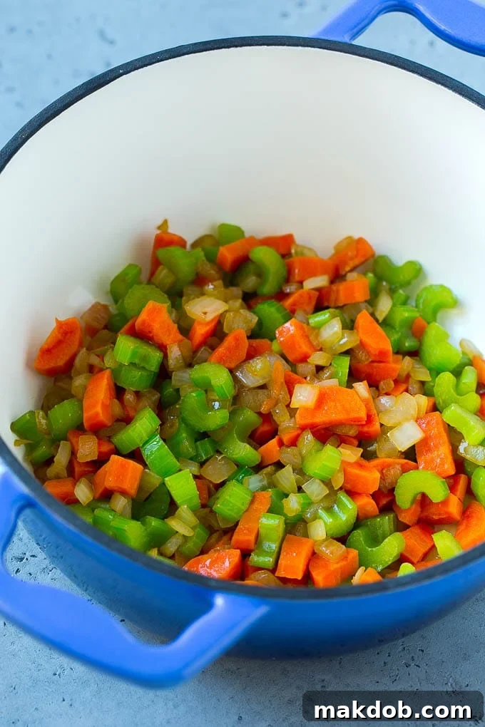 Mexican Chicken Soup | Chicken and Vegetable Soup | Chicken and Potato Soup #chicken #soup #chickensoup #mexican #healthy #dinner #dinneratthezoo Onion, carrot, and celery sautéing in a soup pot, forming the aromatic base for Mexican chicken soup.