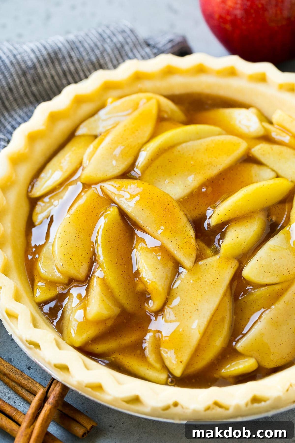 Homemade apple pie filling nestled in an unbaked pie crust, ready for baking.