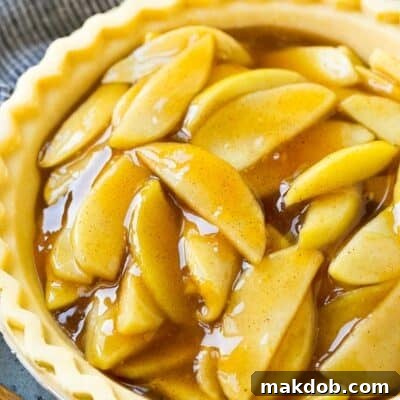 Homemade apple pie filling in an unbaked pie crust, ready for baking.