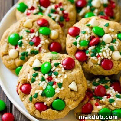 Holiday Monster Cookies 2 A plate of Christmas monster cookies which are decorated with M&M's, white chocolate and sprinkles.