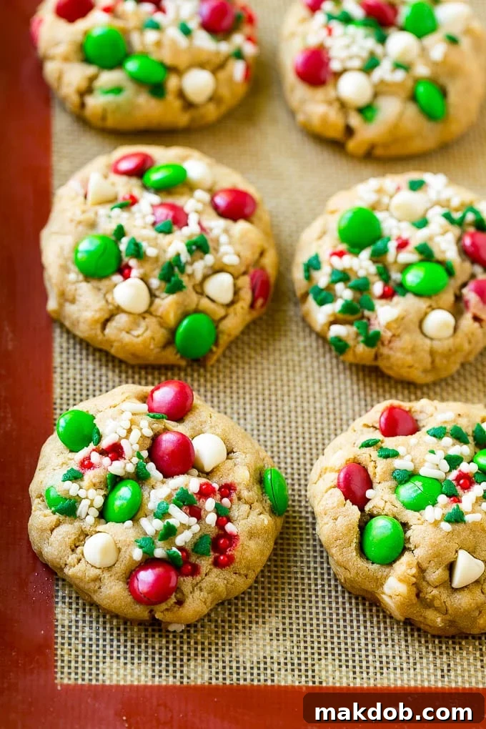 Christmas Monster Cookies Recipe | Oatmeal Cookies | Peanut Butter Cookies | M&M's Cookies #baking #cookies #dessert #peanutbutter #chocolate #dinneratthezoo #christmas #sprinkles Baked Christmas cookies on a sheet pan.