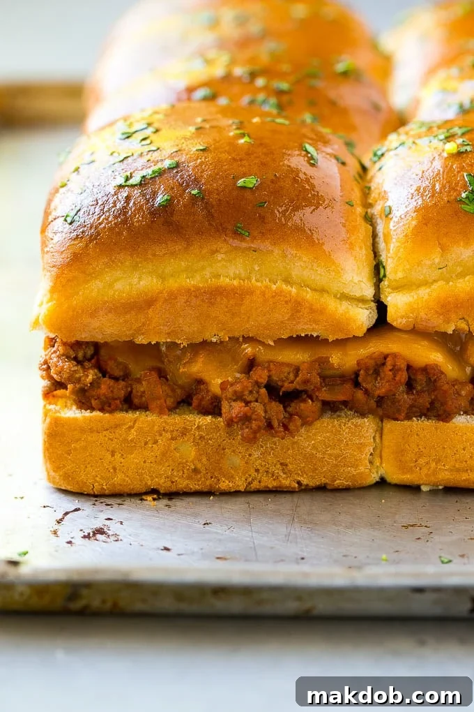 Tray of ground beef and melted cheddar cheese sliders, baked until golden brown.