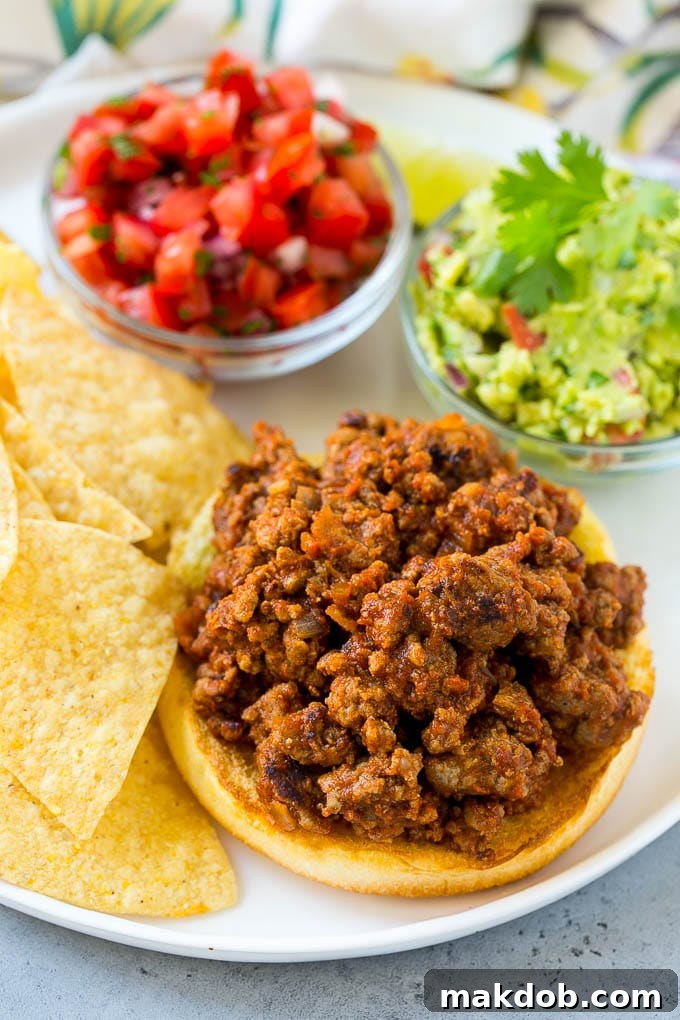 Nacho Sloppy Joes Recipe | Ground Beef Recipe | Easy Sloppy Joes #beef #nachos #cheese #spicy #sandwich #dinner #dinneratthezoo Sloppy joe meat on top of a hamburger bun.