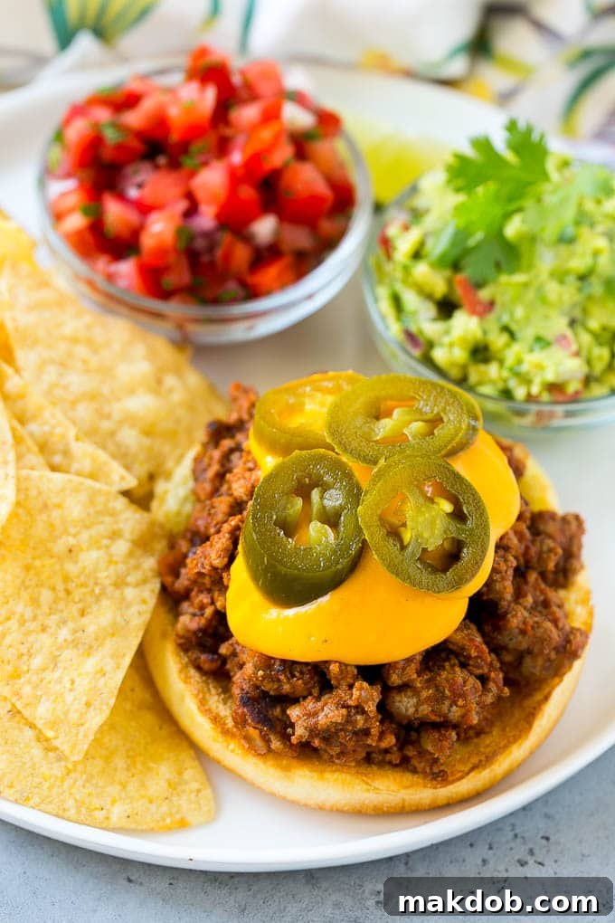 Nacho Sloppy Joes Recipe | Ground Beef Recipe | Easy Sloppy Joes #beef #nachos #cheese #spicy #sandwich #dinner #dinneratthezoo A hamburger bun with sloppy joe meat, nacho cheese sauce and jalapenos.