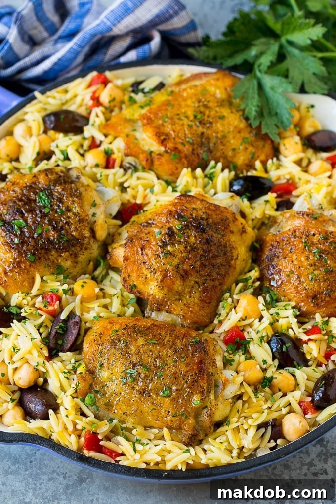 A pan of Mediterranean chicken with orzo, chickpeas and vegetables.