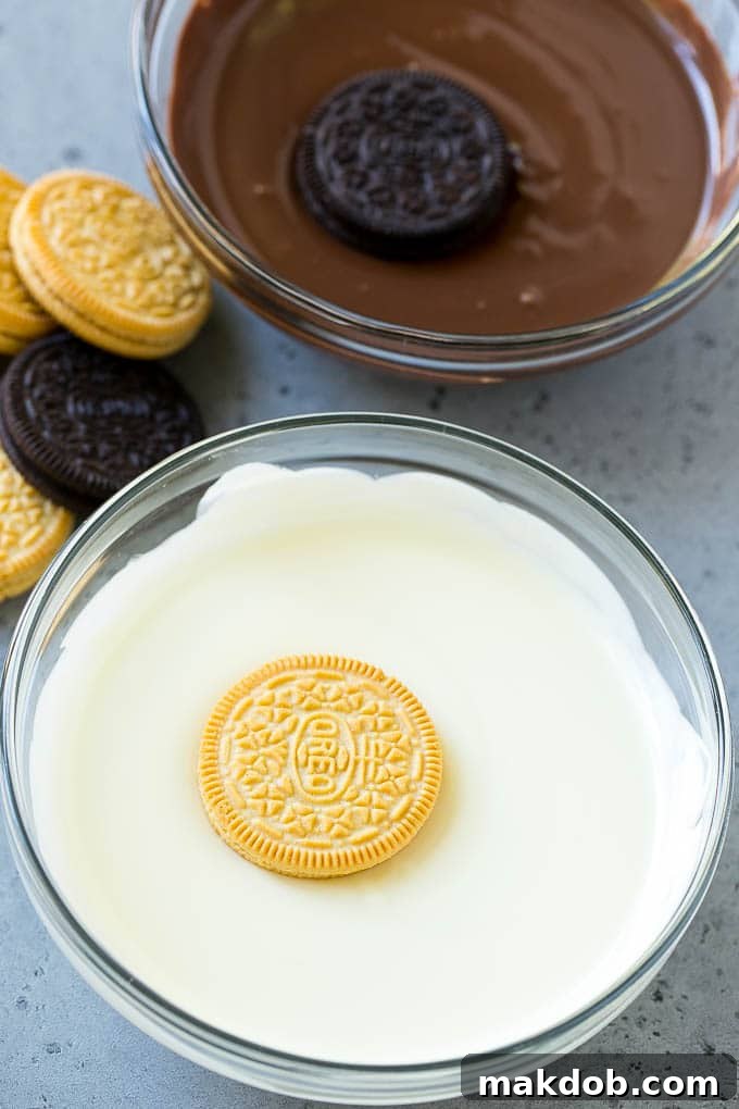 Oreo cookies being dipped into dark and white chocolate candy melts.