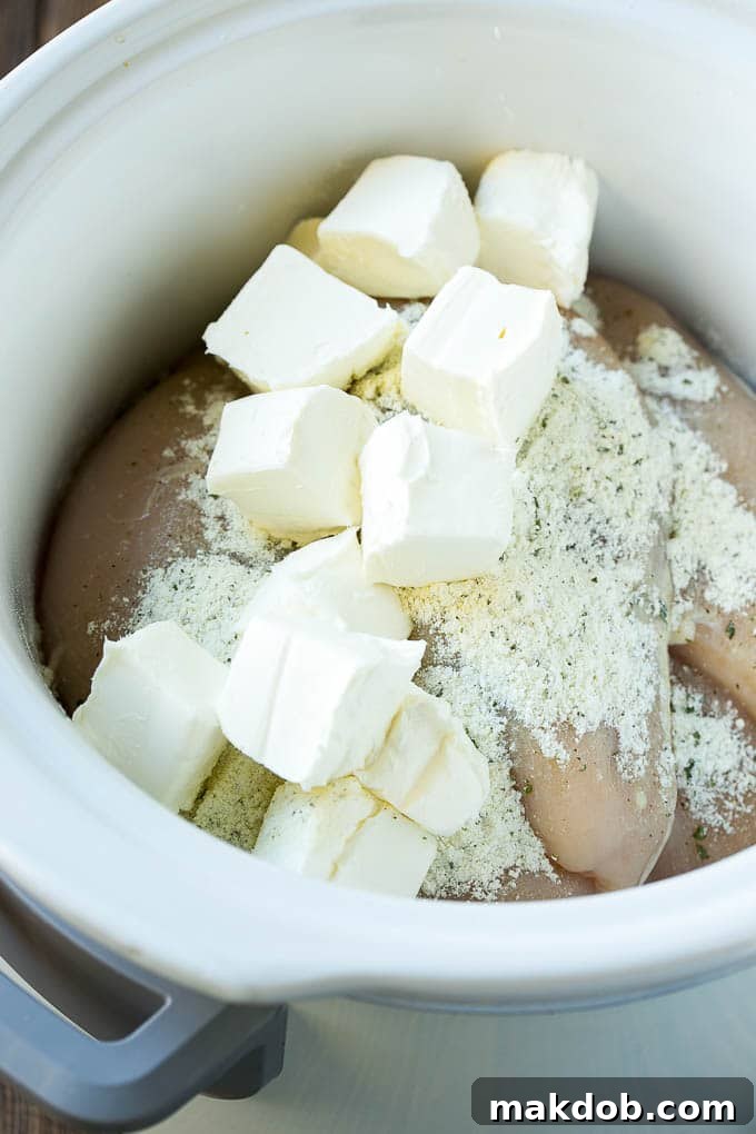 Chicken breasts, cream cheese and ranch powder in the crock pot.