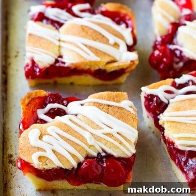 Tangy Cherry Bars with Vanilla Bean Glaze 2 Cherry bars made with almond cookie dough on a sheet pan.