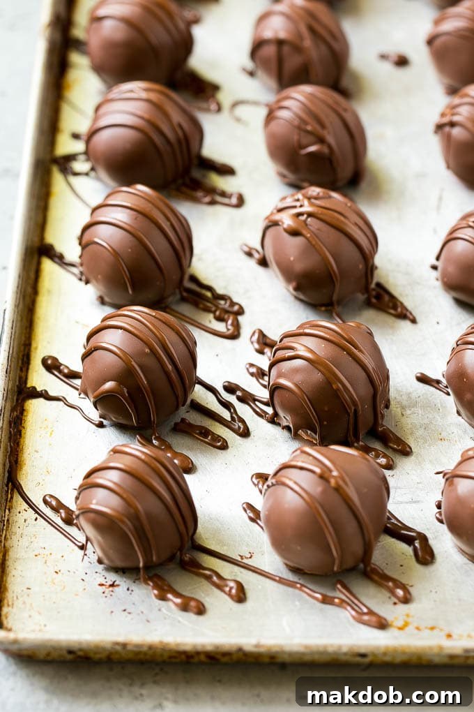 Chocolate Covered Cherries Recipe | Cherry Cordials | Cherry Candy #chocolate #candy #dessert #cherry #sweets #dinneratthezoo Chocolate covered cherries on a sheet pan with a chocolate drizzle on top.