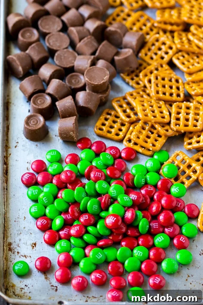 Rolo Pretzels Recipe | Chocolate Pretzels | Caramel Pretzels | Holiday Candy #christmas #baking #dessert #candy #chocolate #caramel #pretzels #dinneratthezoo A simple display of the three essential ingredients: M&M's, square pretzels, and Rolo candies.