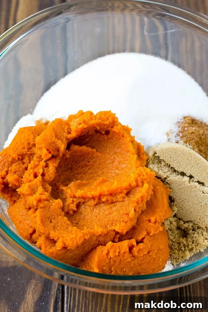 Bowls of pumpkin puree, brown sugar, and flour, ingredients for baking.