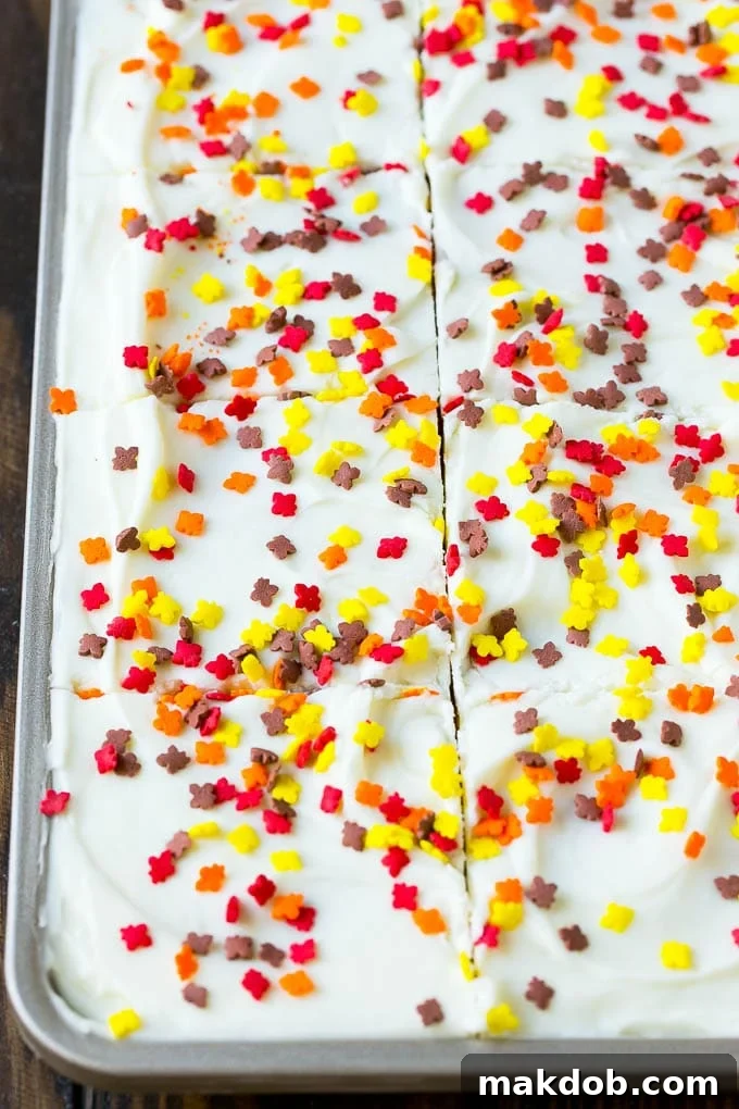 Pumpkin bars topped with a generous layer of cream cheese frosting and colorful sprinkles.