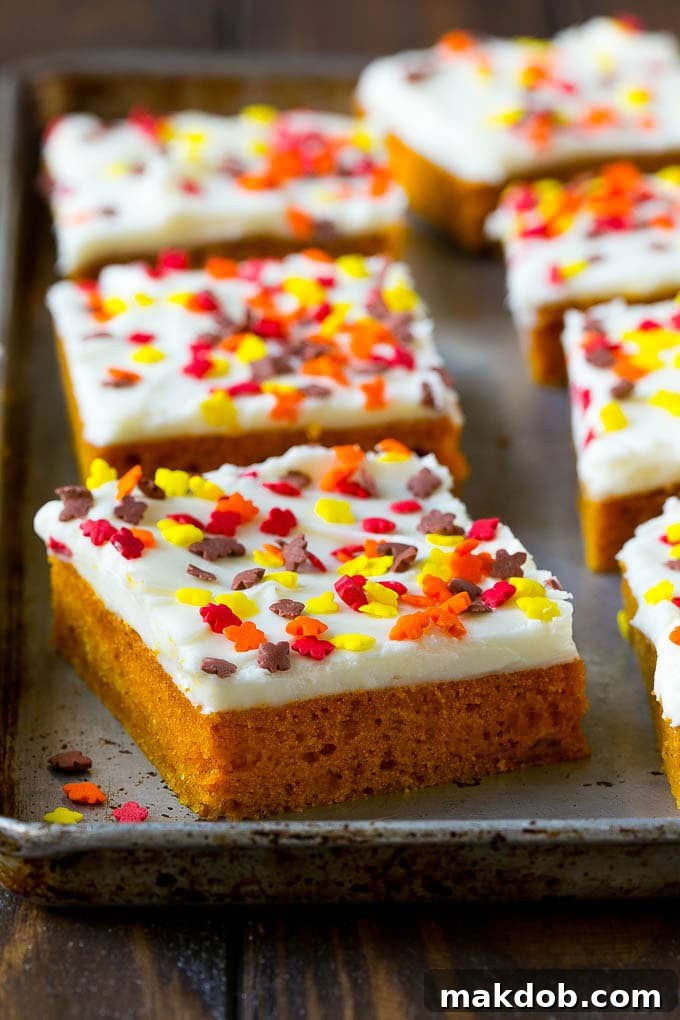 A baking sheet filled with freshly frosted pumpkin bars, ready to be cut into servings.