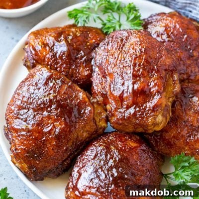 A plate of smoked chicken thighs coated in spice rub and barbecue sauce.