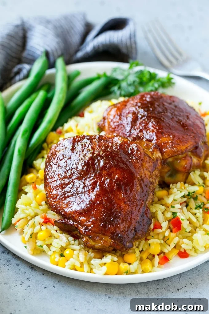Juicy Smoked Chicken Thighs 6 A serving of smoked chicken thighs presented with fluffy rice and vibrant green beans.