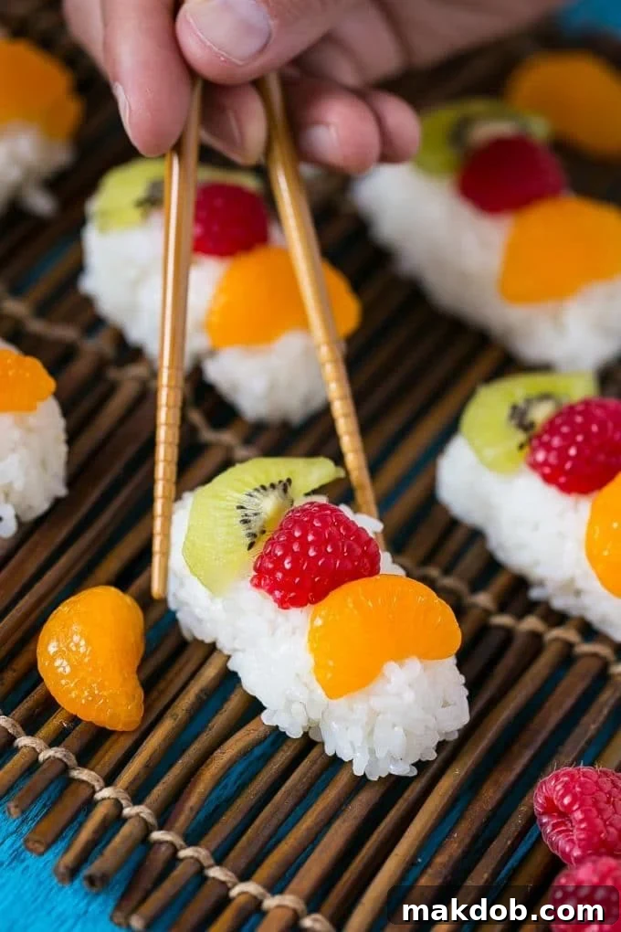 Chopsticks going to pick up a piece of dessert sushi.