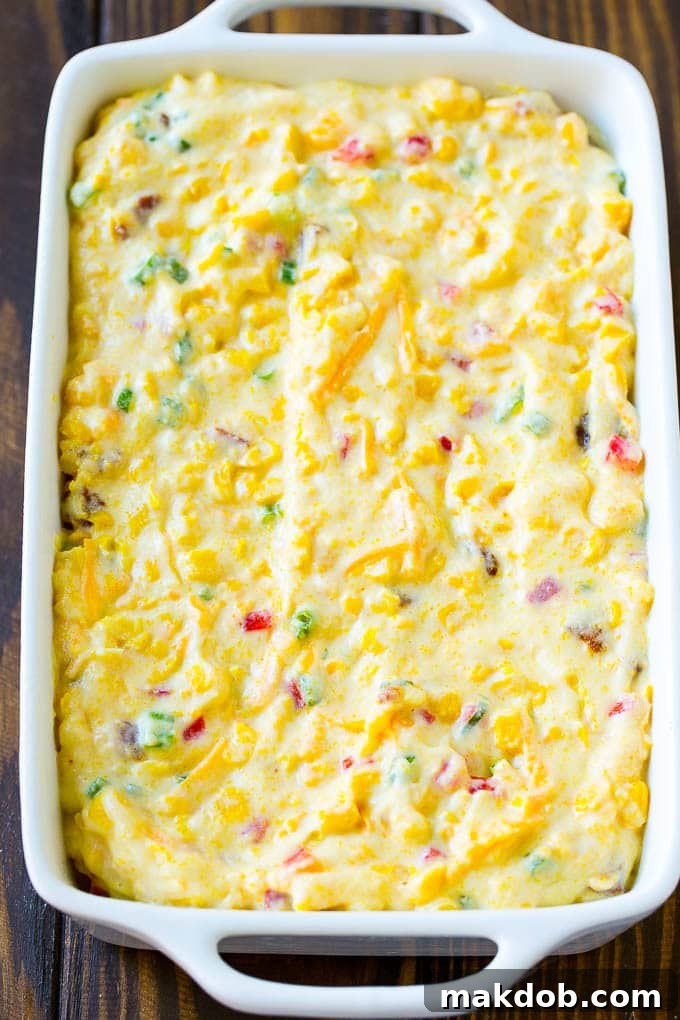 Loaded Corn Casserole Recipe | Easy Corn Casserole | Bacon Corn Casserole | Corn Pudding #corn #casserole #bacon #cheese #sidedish #thanksgiving #dinner #dinneratthezoo Uncooked corn casserole batter beautifully spread in a prepared baking dish, ready for the oven.