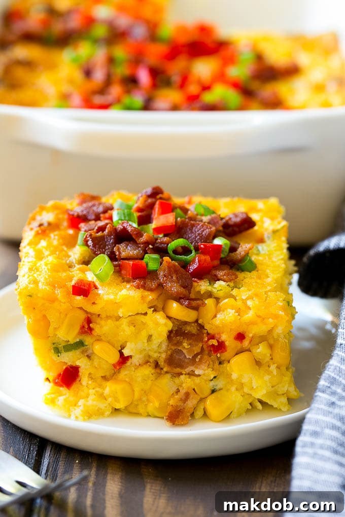 Loaded Corn Casserole Recipe | Easy Corn Casserole | Bacon Corn Casserole | Corn Pudding #corn #casserole #bacon #cheese #sidedish #thanksgiving #dinner #dinneratthezoo A delicious serving of corn casserole, showcasing its rich texture and generous filling of bacon, cheese, and colorful peppers.