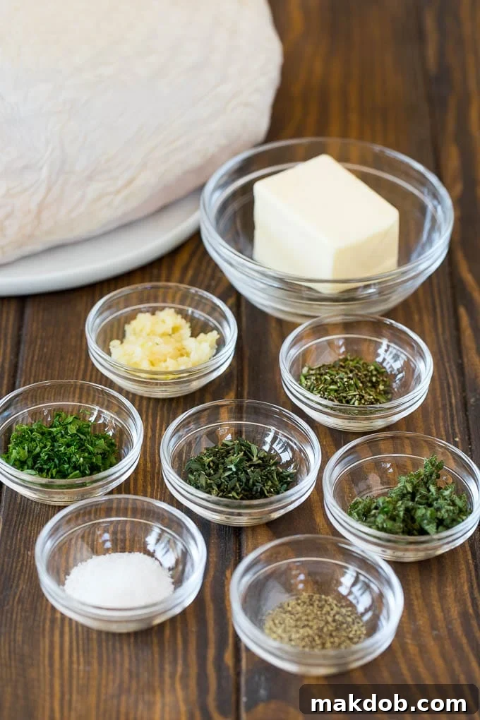 Ingredients including bowls of softened butter, minced garlic, and fresh herbs like rosemary and thyme.