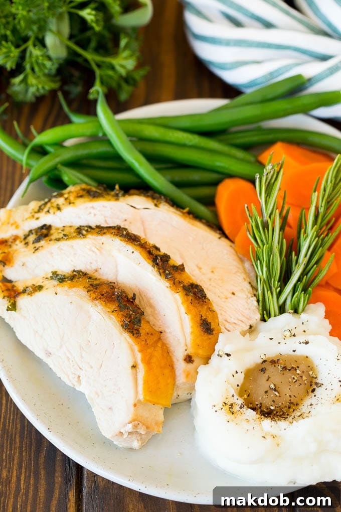 Sliced roasted turkey breast served elegantly with creamy mashed potatoes and vibrant green vegetables.