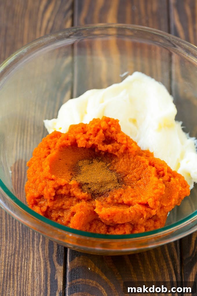Puree, cream cheese and spices in a bowl, ready to be mixed for the pumpkin dip.