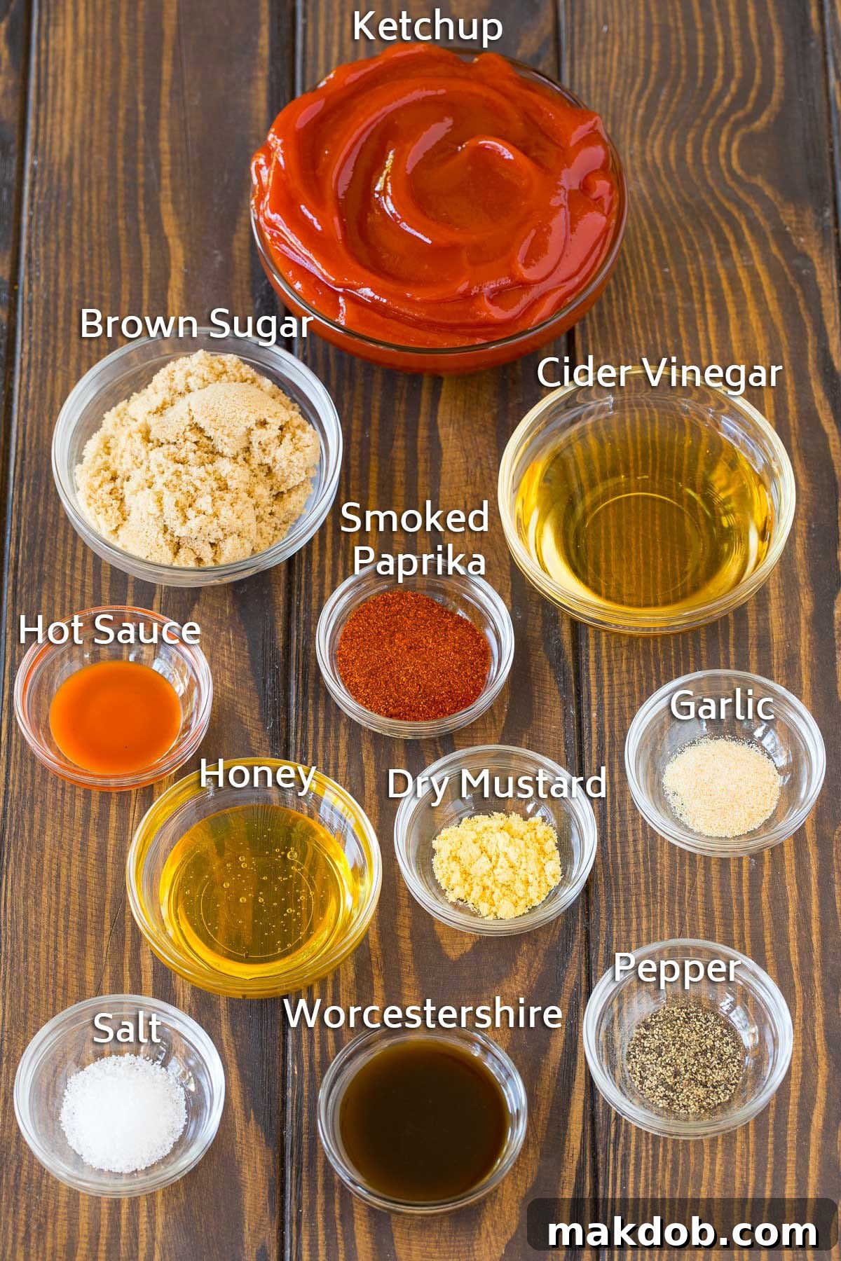 Signature Backyard BBQ Sauce 3 A collection of bowls showcasing the individual ingredients for homemade BBQ sauce, including ketchup, apple cider vinegar, brown sugar, honey, and various spices.