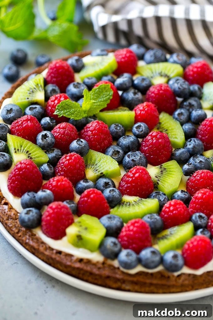 A brownie pizza topped with raspberries, blueberries and kiwis.