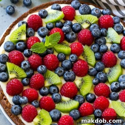 Brownie pizza topped with cream cheese frosting and fresh fruit.