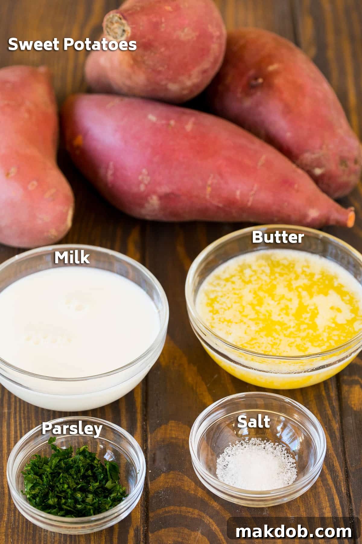 Ingredients for mashed sweet potatoes including milk, butter, salt, and parsley in small bowls, ready for preparation.