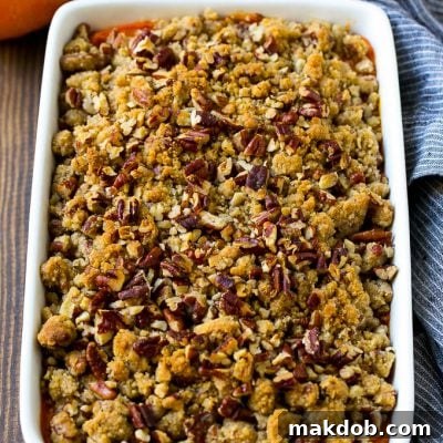 Sweet potato casserole with pecans and brown sugar streusel in a baking dish.