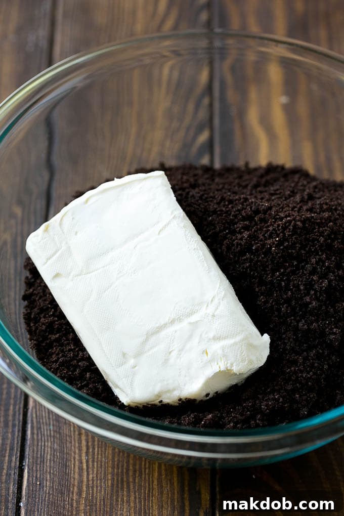 Cookie crumbs and cream cheese in a bowl.
