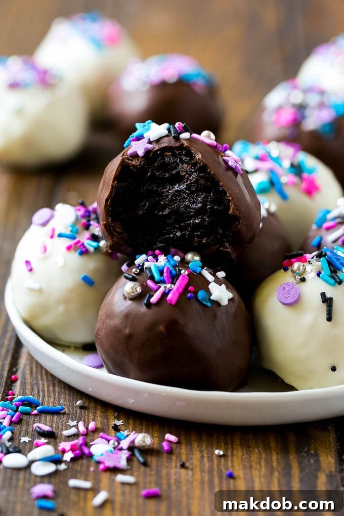 A plate of dark and white chocolate Oreo balls topped with colorful sprinkles.