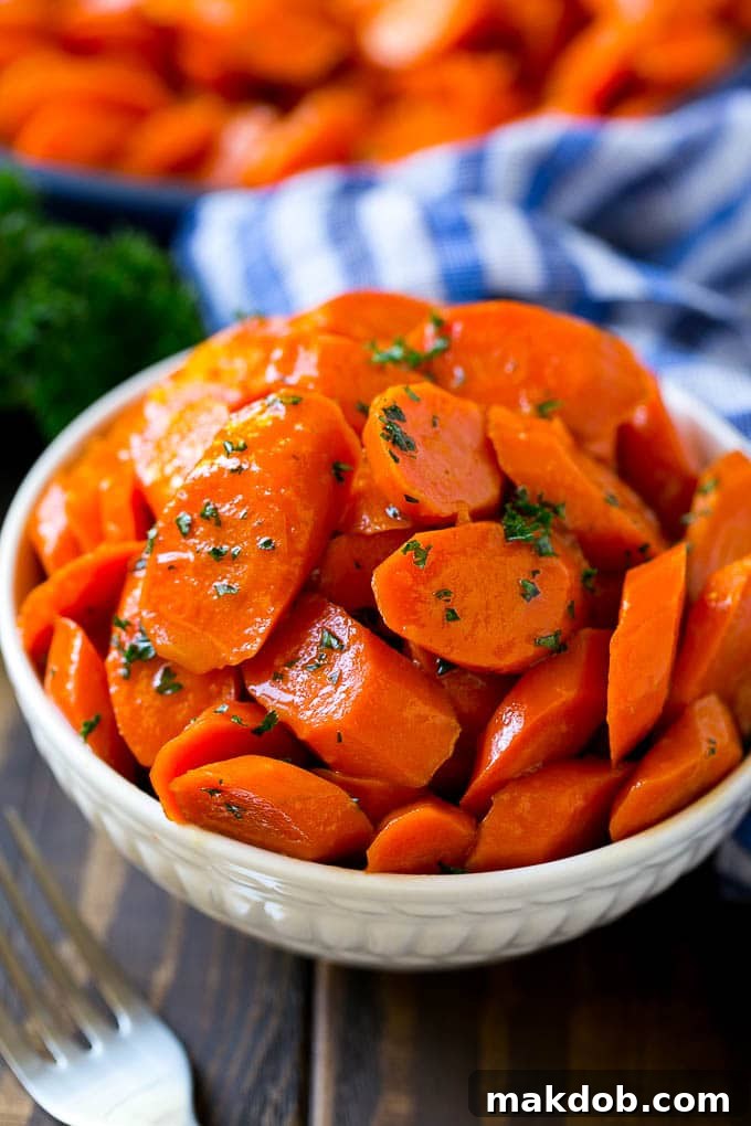 A bowl of glazed carrots topped with parsley.