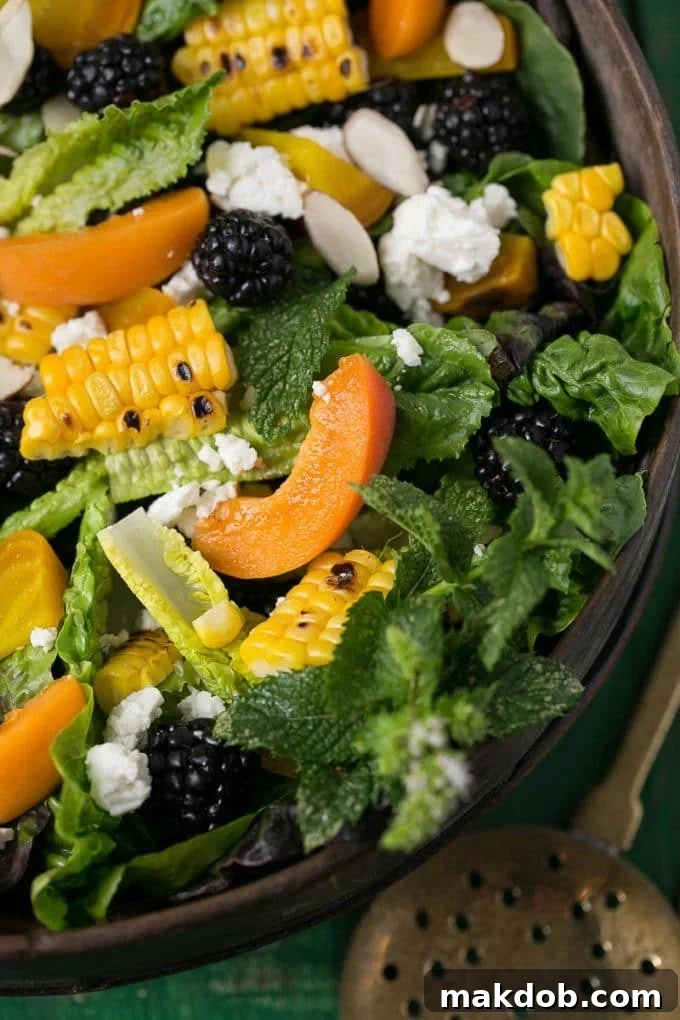 Close-up of a fresh salad featuring vibrant apricot slices and golden corn kernels, highlighting the fresh ingredients.