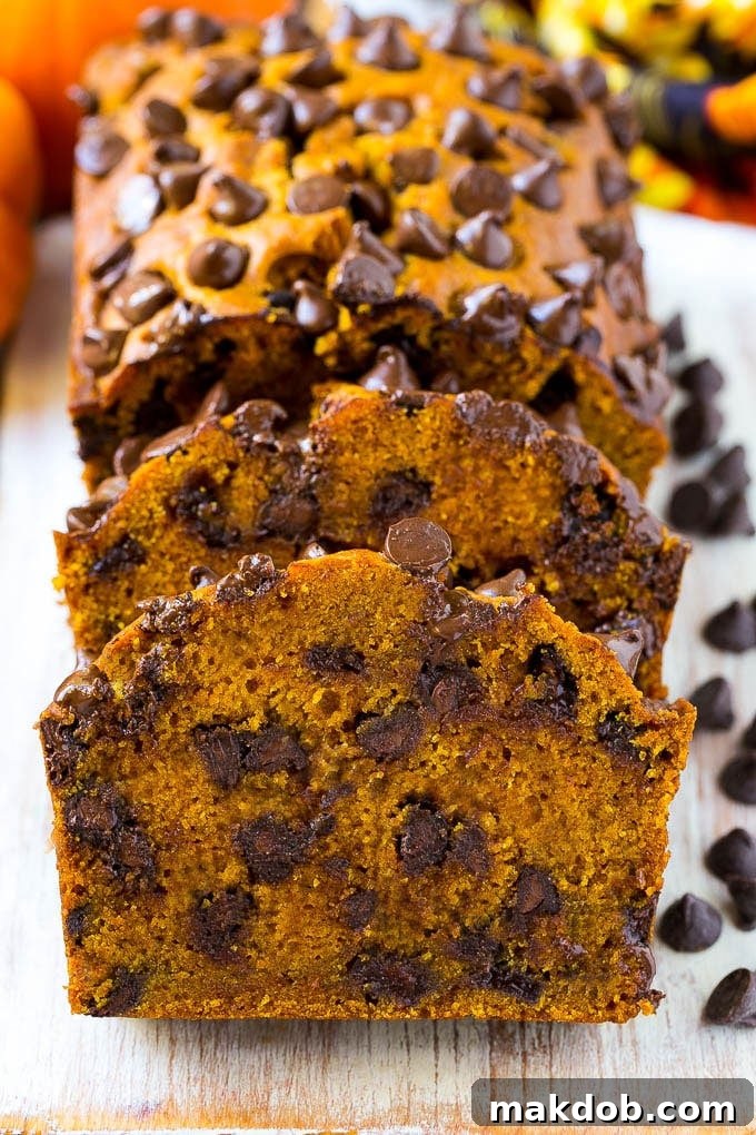 Heavenly Pumpkin Chocolate Chip Bread 2 A perfectly sliced loaf of pumpkin chocolate chip bread, showcasing its moist texture and abundant chocolate chips, artfully arranged on a rustic wooden serving board.