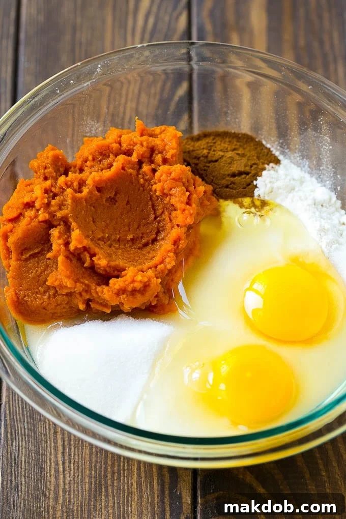 Heavenly Pumpkin Chocolate Chip Bread 3 A composition of key ingredients for pumpkin chocolate chip bread: vibrant pumpkin puree, golden granulated sugar, fresh eggs, all-purpose flour, and aromatic spices gathered in a mixing bowl, ready for preparation.