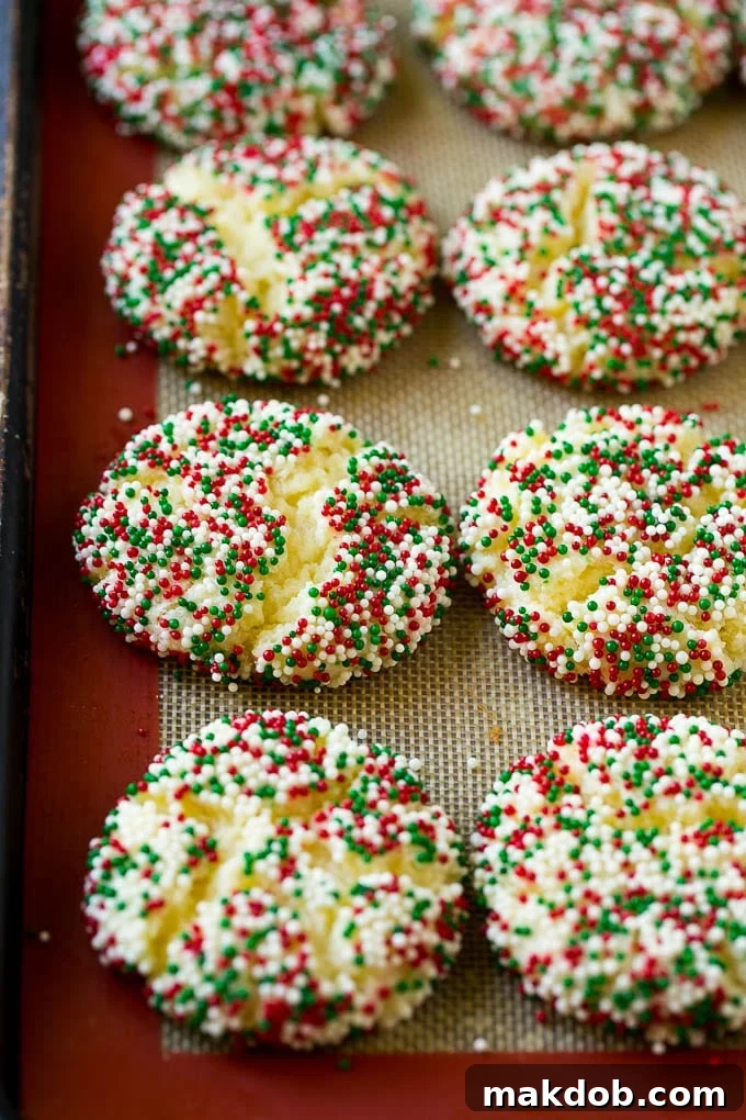 Freshly baked gooey butter cookies, still warm and slightly cracked, cooling on a sheet pan.