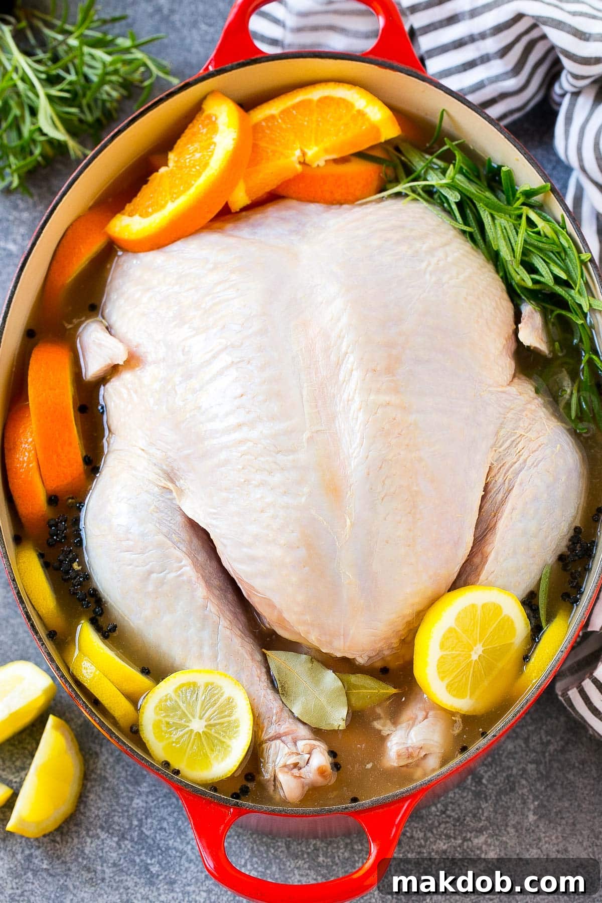 A whole turkey submerged in a rich, amber-colored turkey brine within a large stock pot, ready for refrigeration.