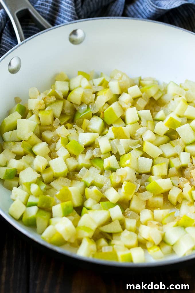 Sauteed onions and apples in a skillet.