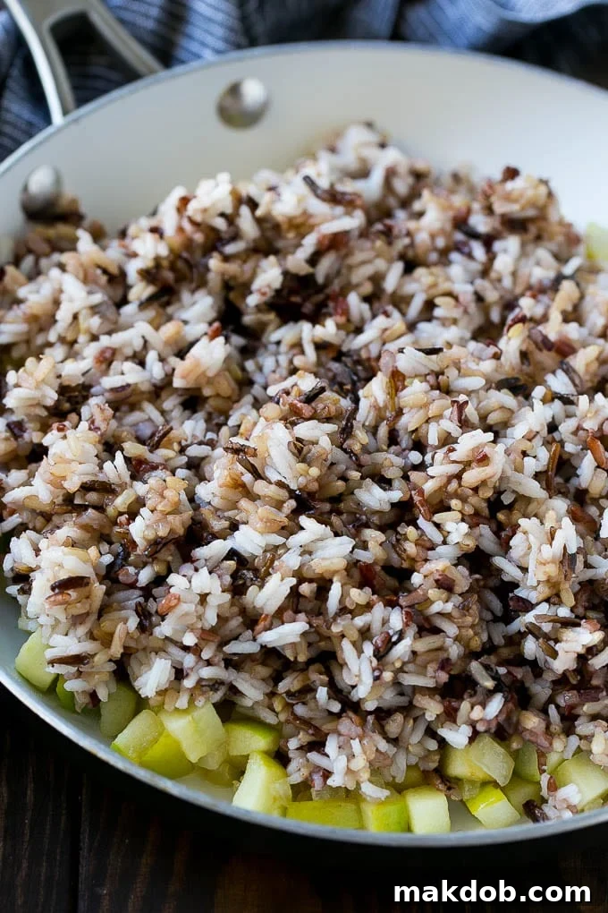 WIld rice, onions and apples in a skillet.