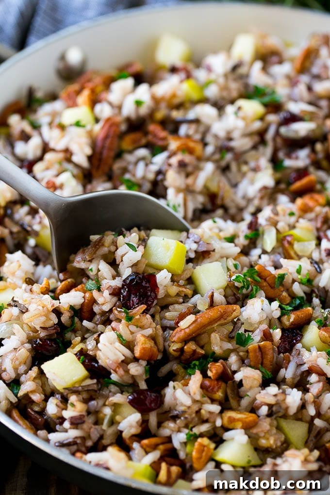 A skillet of rice pilaf with apples, cranberries and pecans.