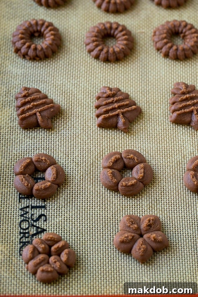 Chocolate spritz cookie dough pressed onto an ungreased baking sheet, ready for the oven.